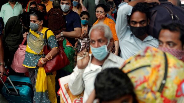 FILE PHOTO: People wearing protective masks leave a railway station amid the spread of the coronavirus disease (COVID-19) in Mumbai, India, 11 December 2020. REUTERS/Francis Mascarenhas/File Photo - Sputnik International