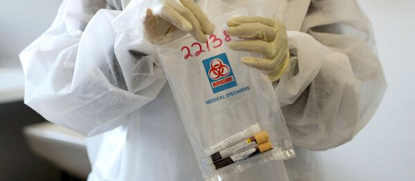 A health worker holds a COVID-19 sample collection kit of a vaccine trials' volunteer, after they were tested for the coronavirus disease and take part in the country's human clinical trial for potential vaccines at the Wits RHI Shandukani Research Centre in Johannesburg, South Africa, August 27, 2020. - Sputnik International