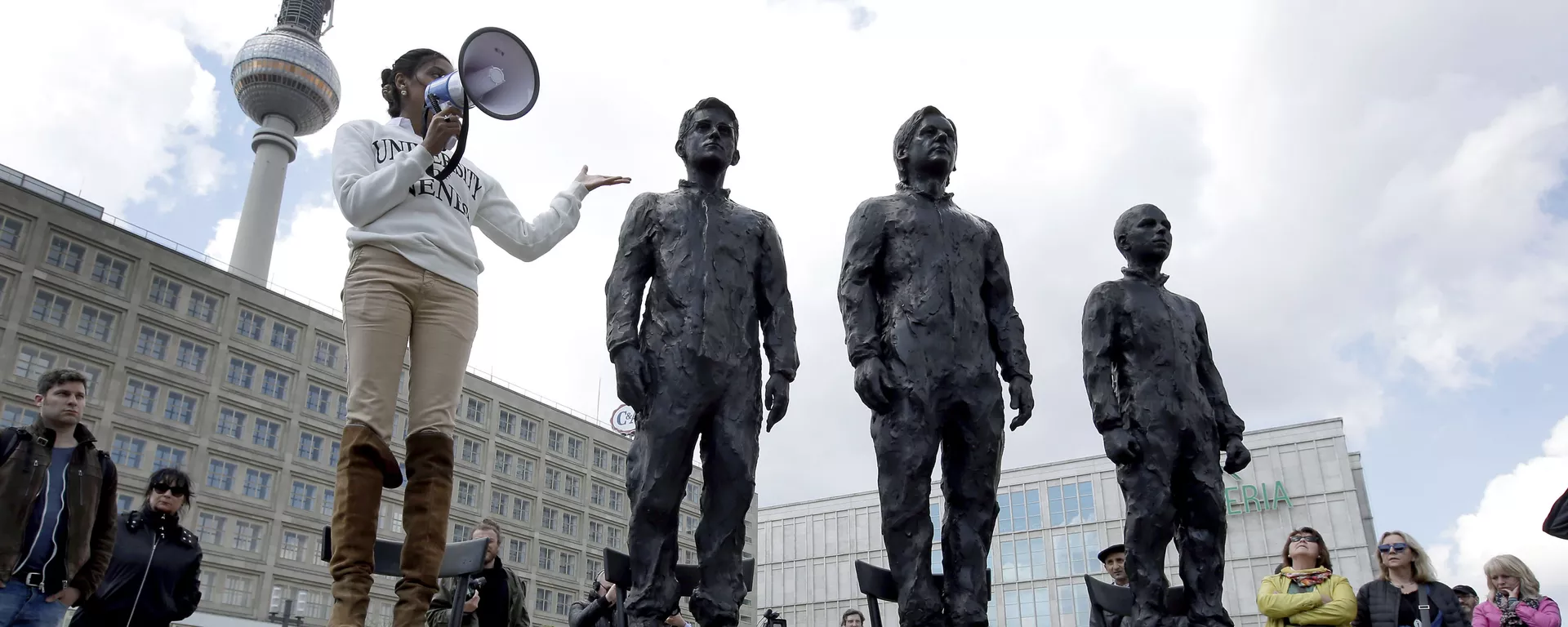 A woman delivers a speech as she stands on a chair of the public art project Anything to Say? at the Alexander Square in Berlin, Germany, Friday, May 1, 2015. The sculpture of the Italian artist Davide Dormino shows the whistleblowers Chelsea Manning, Julian Assange and Edward Snowden, from right, to honour their courage. (AP Photo/Michael Sohn) - Sputnik International, 1920, 21.02.2024