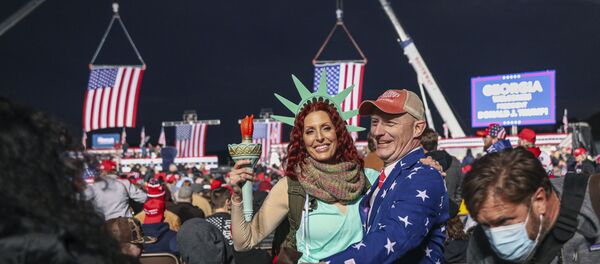 Supporters mingle before a rally with the US president in support of Republican incumbent senators Kelly Loeffler and David Perdue ahead of a Senate runoff in Dalton, Georgia on January 4, 2021. - President Donald Trump, still seeking ways to reverse his election defeat, and President-elect Joe Biden converge on Georgia on Monday for dueling rallies on the eve of runoff votes that will decide control of the US Senate. Trump, a day after the release of a bombshell recording in which he pressures Georgia officials to overturn his November 3 election loss in the southern state, is to hold a rally in the northwest city of Dalton in support of Republican incumbent senators Kelly Loeffler and David Perdue. (Photo by SANDY HUFFAKER / AFP) - Sputnik International
