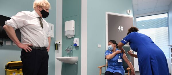 Britain's Prime Minister Boris Johnson looks on as Jennifer Dumasi receives the Oxford University/AstraZeneca COVID-19 vaccine during his visit at the Chase Farm Hospital, in north London, Britain January 4, 2021. - Sputnik International