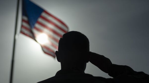 In this photo taken Aug. 26, 2019 and released by the U.S. Air Force, U.S. Air Force Staff Sgt. Devin Boyer, 435th Air Expeditionary Wing photojournalist, salutes the flag during a ceremony signifying the change from tactical to enduring operations at Camp Simba, Manda Bay, Kenya - Sputnik International