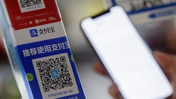 Customer uses a phone to scan the QR code of the electronic payment service Alipay that belongs to Ant Group Co Ltd at a market stall in Beijing, China, December 31, 2020 - Sputnik International