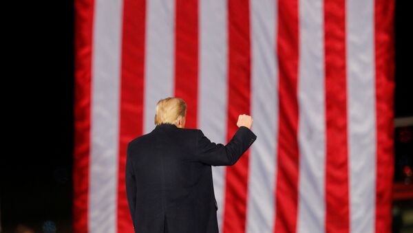 U.S. President Donald Trump gestures in front of a U.S. flag while campaigning for Republican Senator Kelly Loeffler on the eve of the run-off election to decide both of Georgia's Senate seats, in Dalton, Georgia, U.S., January 4, 2021. - Sputnik International