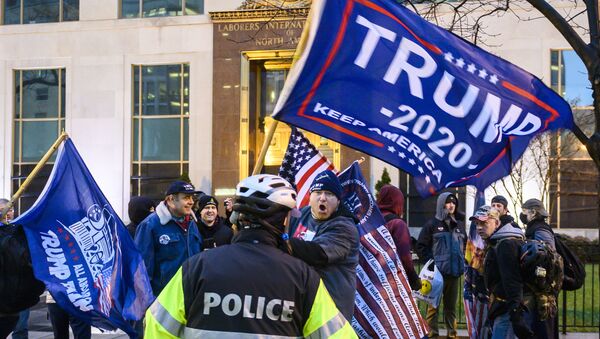 Pro-Trump supporters stand behind police as they argue with counter protesters during a confrontation near Black Lives Matter plaza in Washington, DC on January 5, 2021, on the eve of a rally of supporters of US President Donald Trump to protest the upcoming certification of Joe Biden's Electoral College as president.  - Sputnik International