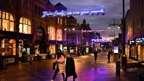 People walk past shops, temporarily closed down due to current coronavirus restrictions, in Leeds, northern England on January 6, 2021, on the second day of Britain's national lockdown to combat the spread of COVID-19. - Sputnik International