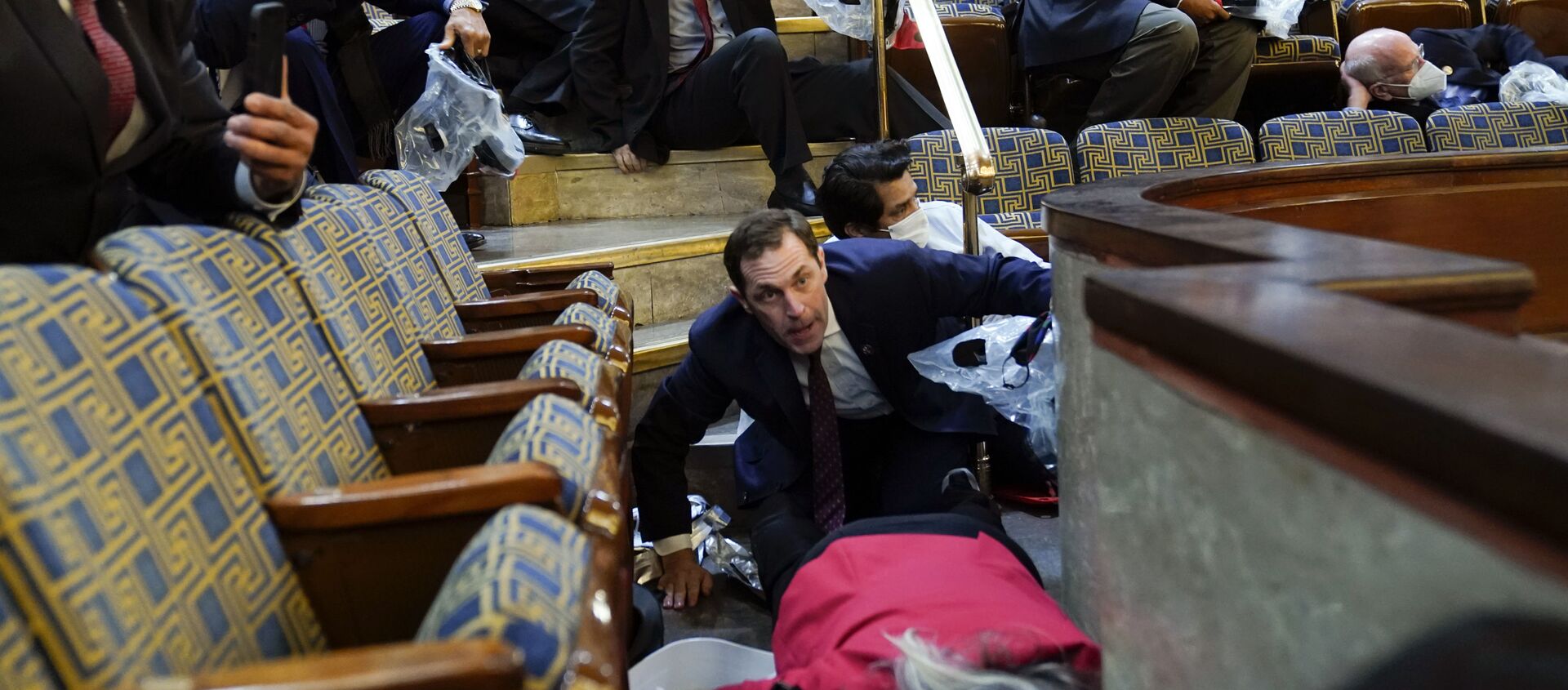 People shelter in the House gallery as protesters try to break into the House Chamber at the U.S. Capitol on Wednesday, Jan. 6, 2021, in Washington. - Sputnik International, 1920, 06.01.2021