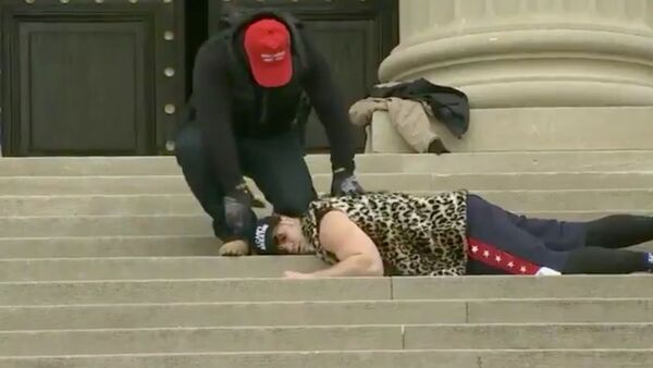 Screenshot captures two unidentified individuals recreating the death of Minnesota man George Floyd on the steps of the National City Christian Church in Washington DC. - Sputnik International