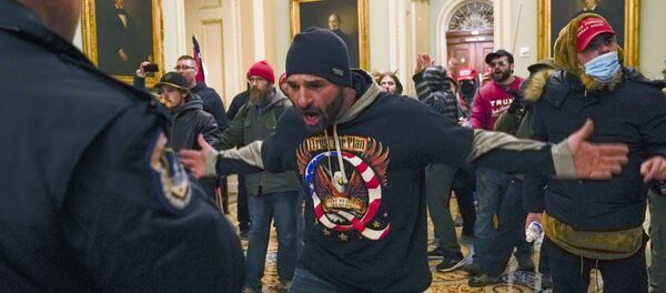 Trump supporters gesture to U.S. Capitol Police in the hallway outside of the Senate chamber at the Capitol in Washington, Wednesday, Jan. 6, 2021. (AP Photo/Manuel Balce Ceneta) - Sputnik International