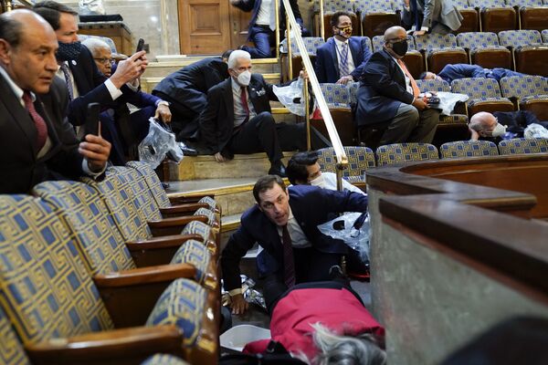 People shelter in the House gallery as protesters try to break into the House Chamber at the U.S. Capitol on Wednesday, 6 January 2021, in Washington - Sputnik International