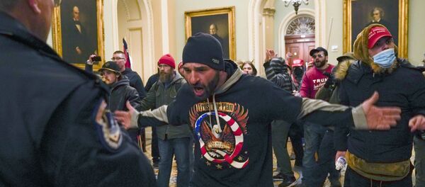 Trump supporters gesture to US Capitol Police in the hallway outside of the Senate chamber at the Capitol in Washington, Wednesday, 6 January 2021 - Sputnik International