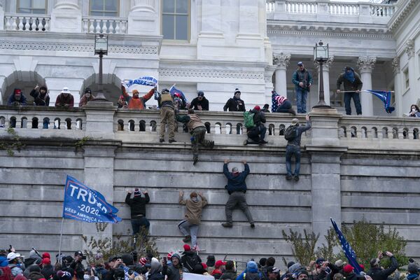 Supporters of President Donald Trump climb the west wall of the the US Capitol on Wednesday, 6 January 2021, in Washington - Sputnik International