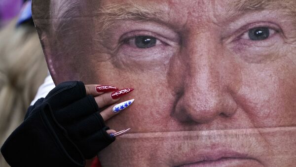 A woman holds a cut-out of President Donald Trump's face Wednesday, 6 January 2021, in Washington, at a rally in support of President Donald Trump called the Save America Rally. - Sputnik International