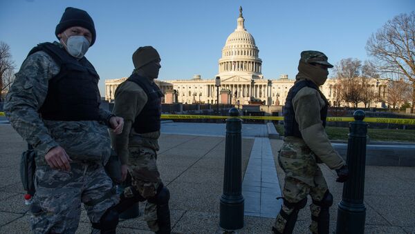 Members of the DC National Guard walk past the US Capitol in Washington, DC, on January 7, 2021, one day after supporters of outgoing President Donald Trump stormed the building. - Sputnik International