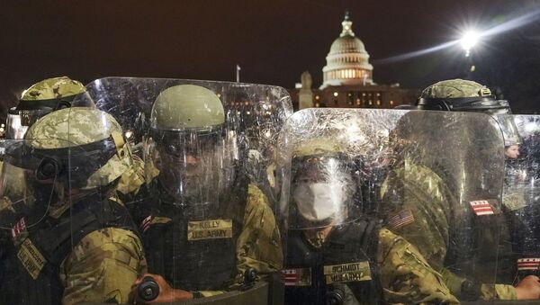 DC National Guard stand outside the Capitol, Wednesday night, Jan. 6, 2021, after a day of rioting protesters. - Sputnik International