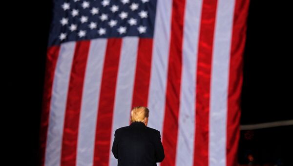U.S. President Donald Trump stands in front of a U.S. flag while campaigning for Republican Senator Kelly Loeffler on the eve of the run-off election to decide both of Georgia's Senate seats, in Dalton, Georgia, U.S., January 4, 2021. - Sputnik International