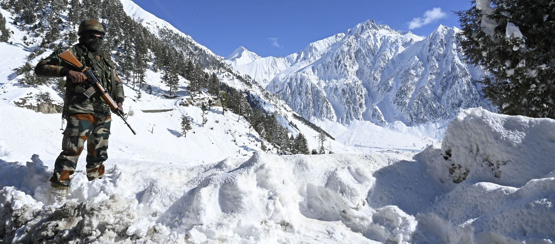 An Indian army soldier stands on a snow covered road after snowfall near Zojila mountain pass that connects Srinagar to the union territory of Ladakh, bordering China on November 26, 2020 - Sputnik International, 1920, 08.02.2021