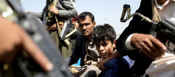 A boy rides with Houthi followers on the back of a patrol truck during the funeral of Houthi fighters A boy rides with Houthi followers on the back of a patrol truck during the funeral of Houthi fighters - Sputnik International