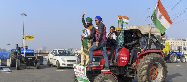 Protesting farmers shout slogans near police barricades as they continue to protest along a blocked highway against the central government's recent agricultural reforms, at the Gazipur Delhi-Uttar Pradesh state border, in Ghaziabad on January 12, 2021.  - Sputnik International