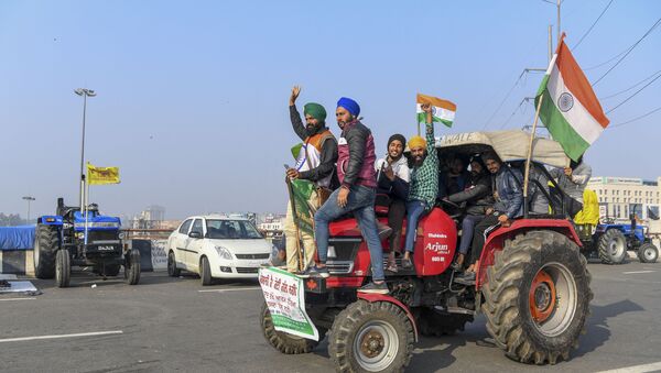 Protesting farmers shout slogans near police barricades as they continue to protest along a blocked highway against the central government's recent agricultural reforms, at the Gazipur Delhi-Uttar Pradesh state border, in Ghaziabad on January 12, 2021.  - Sputnik International