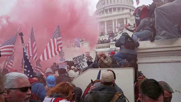 A cloud of colored smoke appears as a mob of supporters of U.S. President Donald Trump storm the U.S. Capitol Building in Washington, U.S., January 6, 2021. Picture taken January 6, 2021.  - Sputnik International