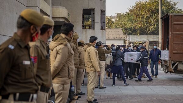 Policemen stand guard as health workers shift a box containing COVID-19 vaccine from a vehicle to a cold storage at Rajiv Gandhi Super Speciality hospital in New Delhi, India, Tuesday, Jan. 12, 2021 - Sputnik International