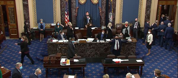 In this image from video, lawmakers evacuate the Senate floor as protesters gain entry into the U.S. Capitol on Wednesday, Jan. 6, 2021. (Senate Television via AP) - Sputnik International