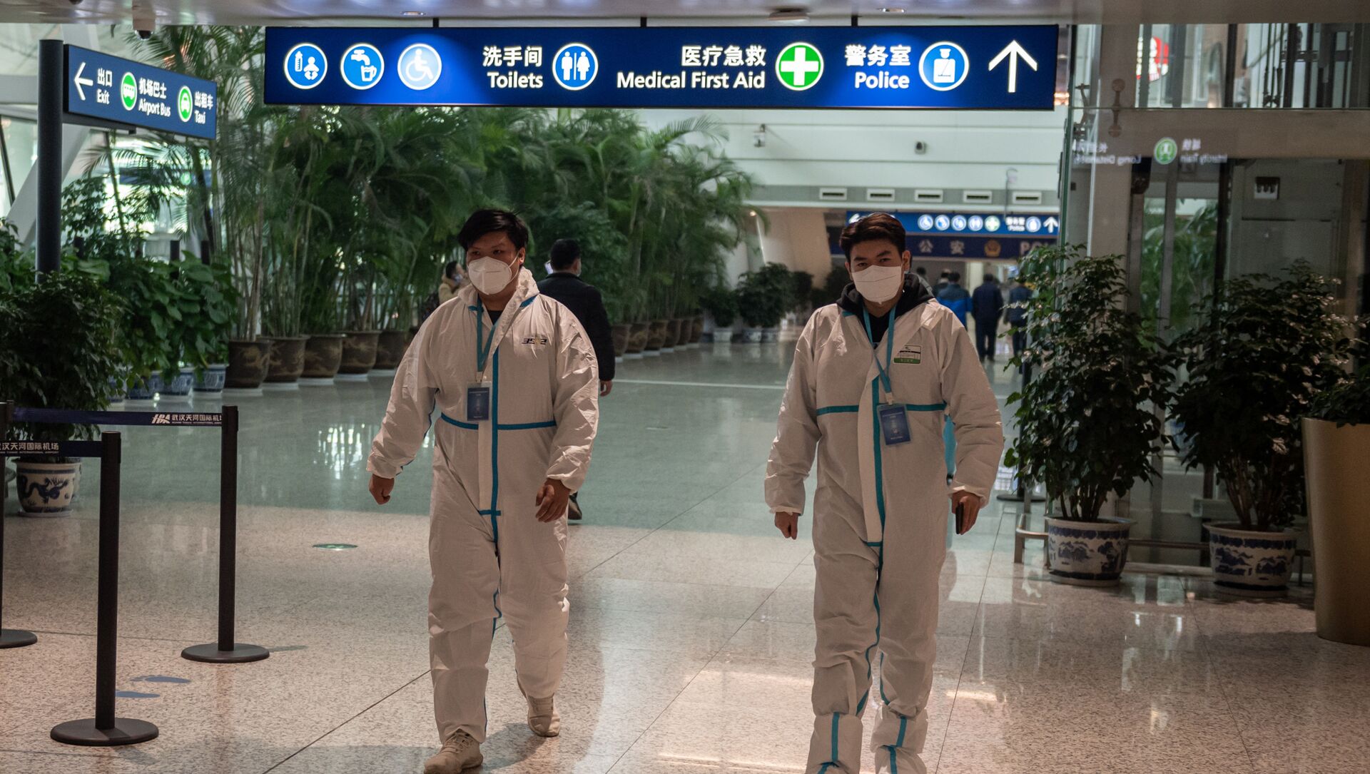 Health workers in suits walk in the international arrivals area, where arriving travelers are to be taken into quarantine, at the international airport in Wuhan on January 14, 2021, ahead of the expected arrival of a World Health Organization (WHO) team investigating the origins of the Covid-19 pandemic. - Sputnik International, 1920, 08.02.2021