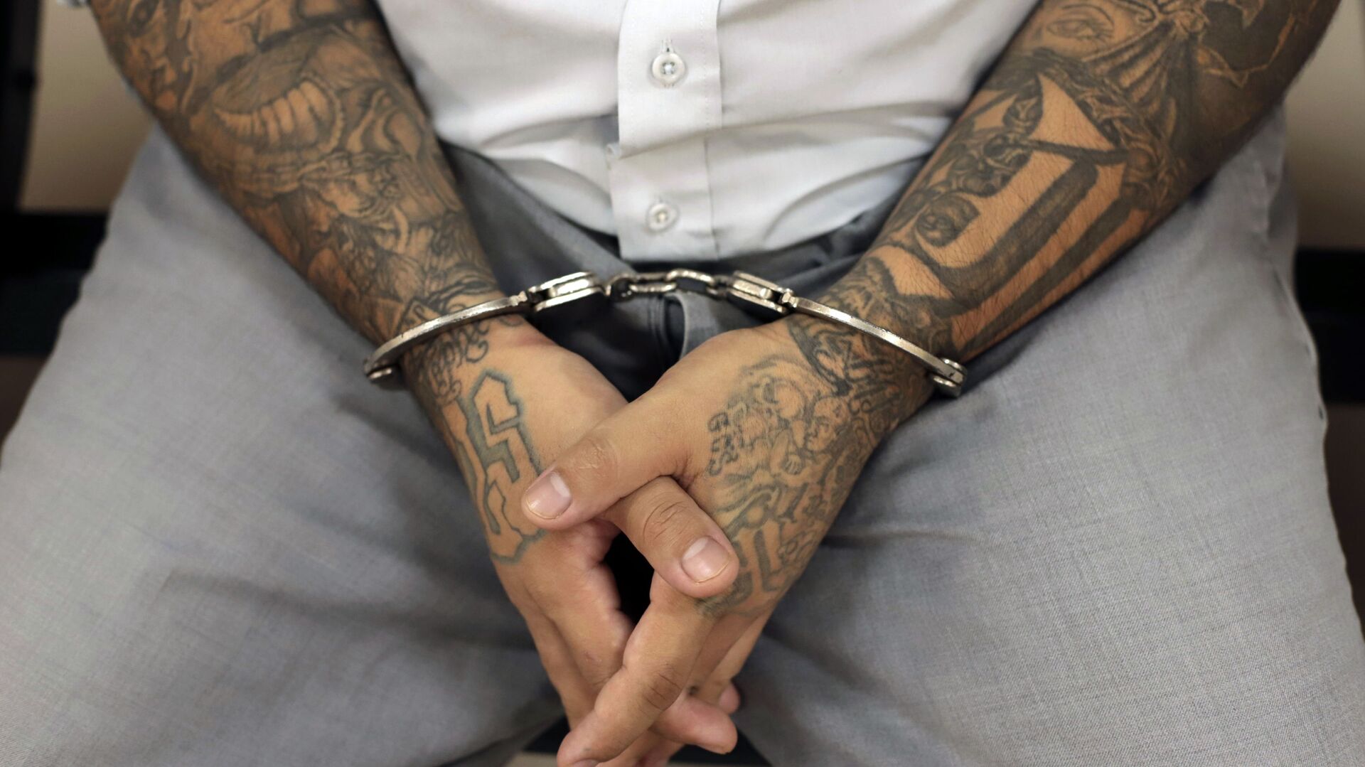 A handcuffed Mara Salvatrucha gang member waits for the start of a court trial at the Isidro Menendez Judicial Center in San Salvador, El Salvador, Thursday, Oct. 10, 2019. El Salvador on Tuesday began a mass trial of over 400 alleged gang members, including purported leaders of the feared transnational crime group Mara Salvatrucha, or MS-13.  - Sputnik International, 1920, 12.04.2022