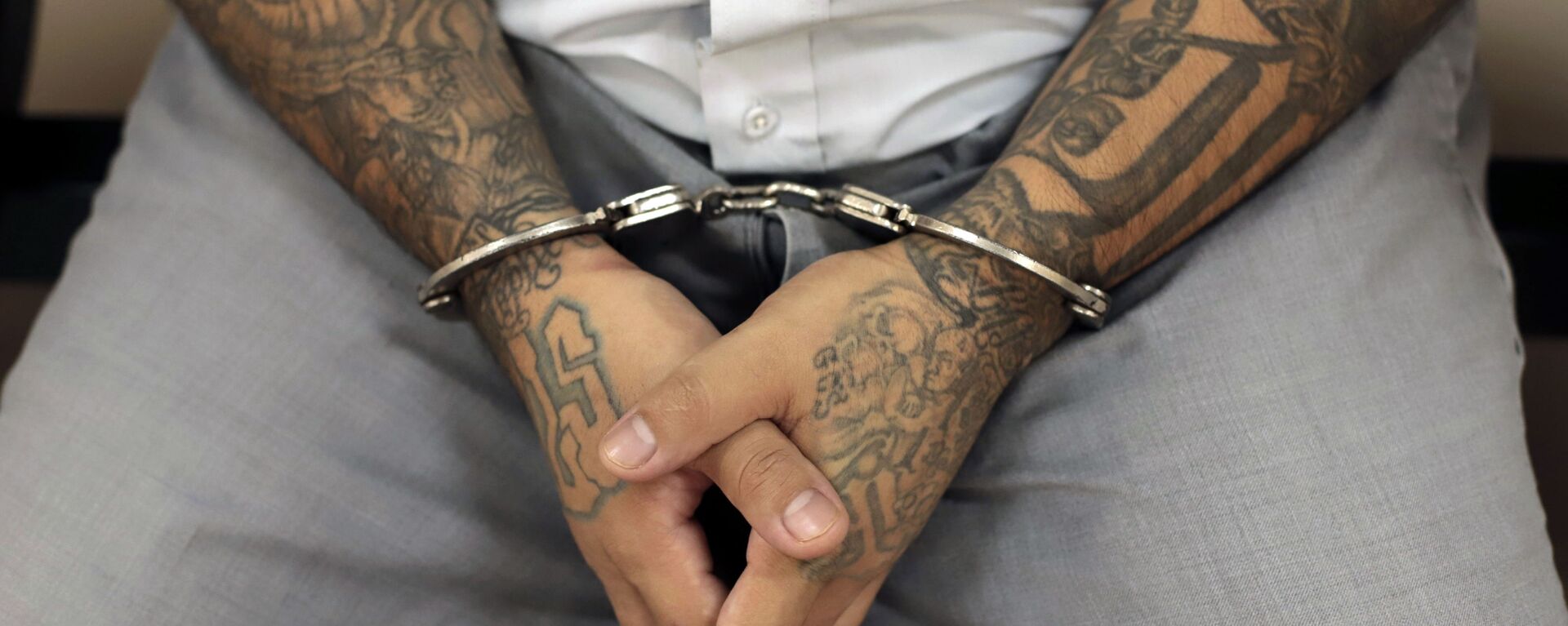 A handcuffed Mara Salvatrucha gang member waits for the start of a court trial at the Isidro Menendez Judicial Center in San Salvador, El Salvador, Thursday, Oct. 10, 2019. El Salvador on Tuesday began a mass trial of over 400 alleged gang members, including purported leaders of the feared transnational crime group Mara Salvatrucha, or MS-13.  - Sputnik International, 1920, 06.02.2025