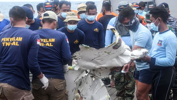 Indonesian Navy members carry the remains of Sriwijaya Air plane flight SJ 182 which crashed into the sea off the Jakarta coast in Indonesia, January 13, 2021 - Sputnik International
