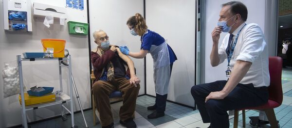 Simon Stevens (R), Chief Executive of the NHS, watches as a nurse (C) administers a dose of the Pfizer-BioNTech Covid-19 vaccine to Frank Naderer (L), 82, at Guy's Hospital in London on 8 December 2020 as the UK starts its biggest ever vaccination programme. Simon Stevens (R), Chief Executive of the NHS, watches as a nurse (C) administers a dose of the Pfizer-BioNTech Covid-19 vaccine to Frank Naderer (L), 82, at Guy's Hospital in London on 8 December 2020 as the UK starts its biggest ever vaccination programme. - Sputnik International