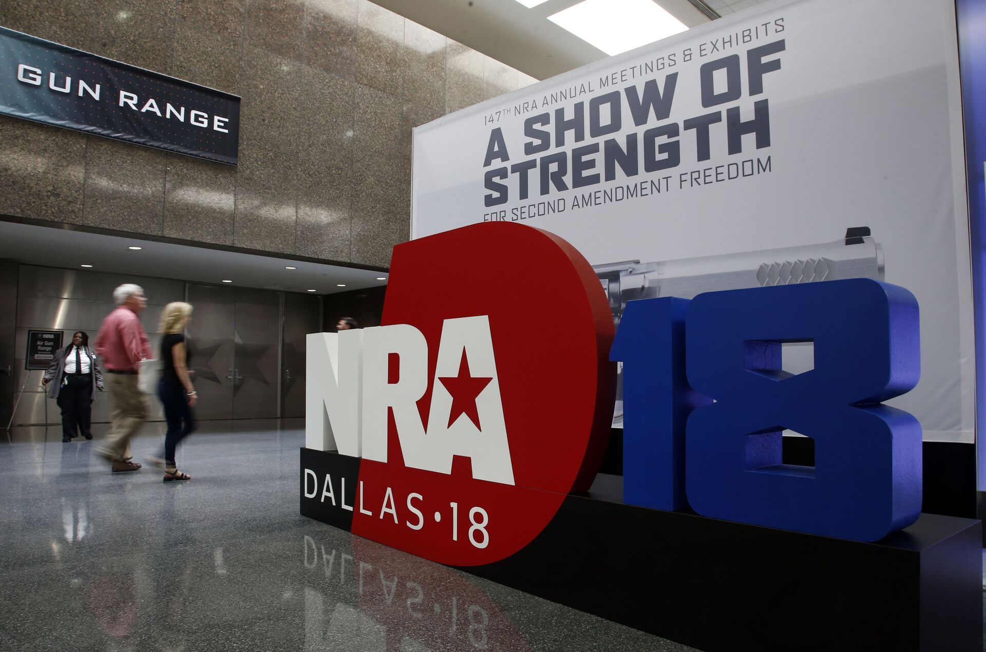 People walk by NRA convention signage in the Kay Bailey Hutchison Convention Center in Dallas, Thursday, May 3, 2018. The convention is scheduled to go through Sunday. - Sputnik International, 1920, 23.06.2022