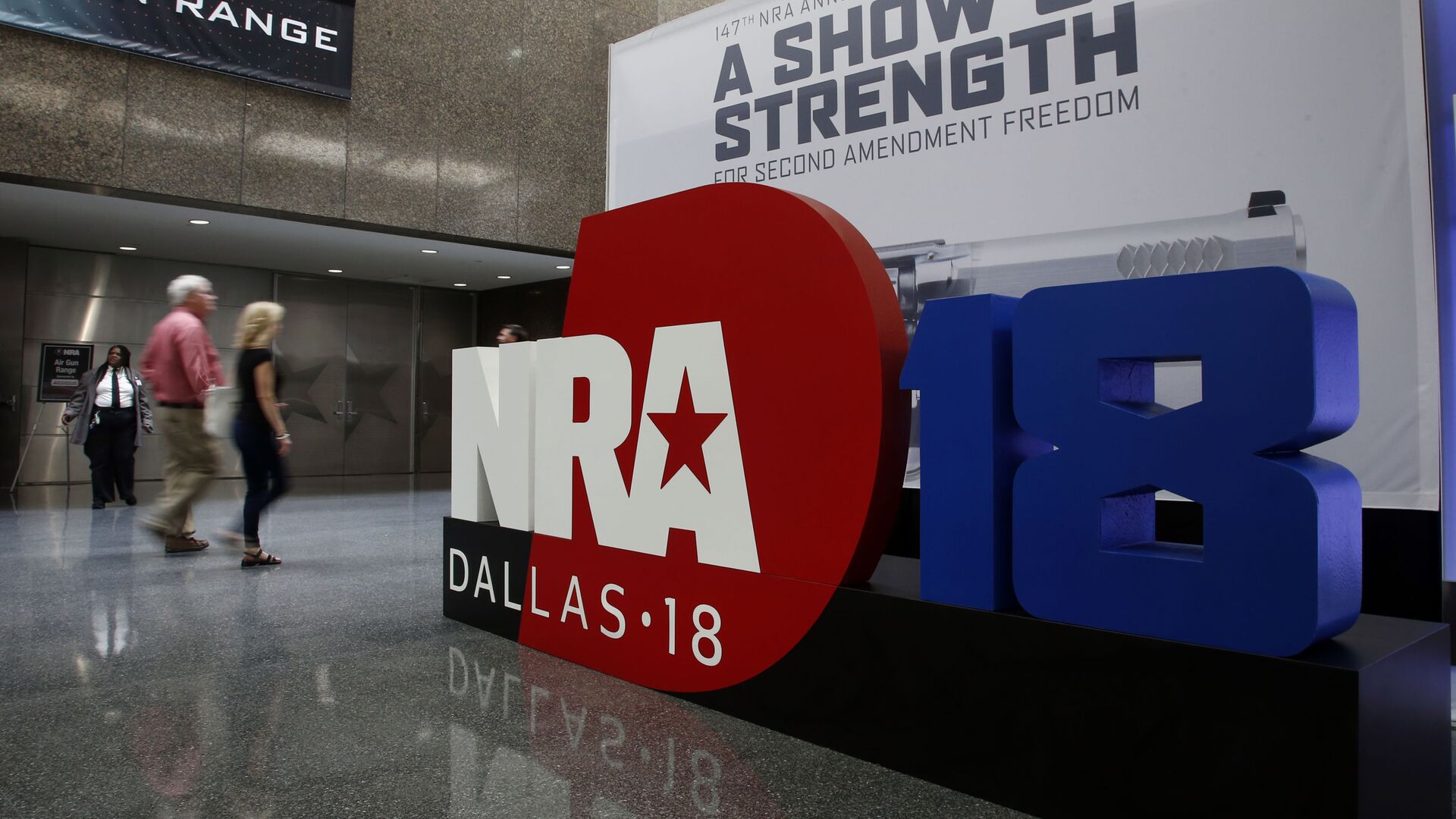 People walk by NRA convention signage in the Kay Bailey Hutchison Convention Center in Dallas, Thursday, May 3, 2018. The convention is scheduled to go through Sunday. - Sputnik International, 1920, 27.10.2021