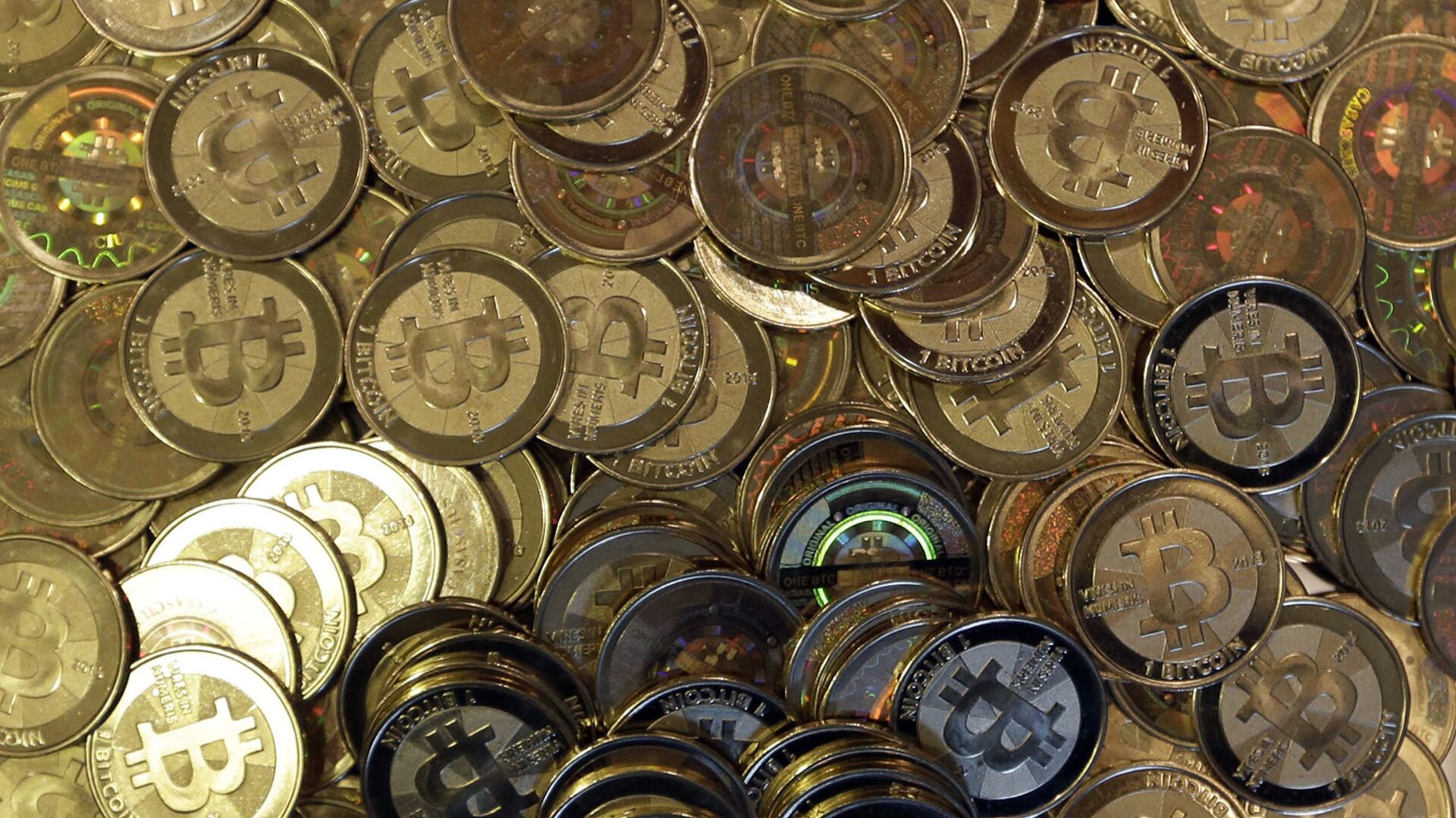 This April 3, 2013, file photo shows bitcoin tokens in Sandy, Utah. Unidentified hackers broke into the Twitter accounts of technology moguls, politicians, celebrities and major companies Wednesday, July 15, 2020, in an apparent Bitcoin scam - Sputnik International, 1920, 22.02.2021