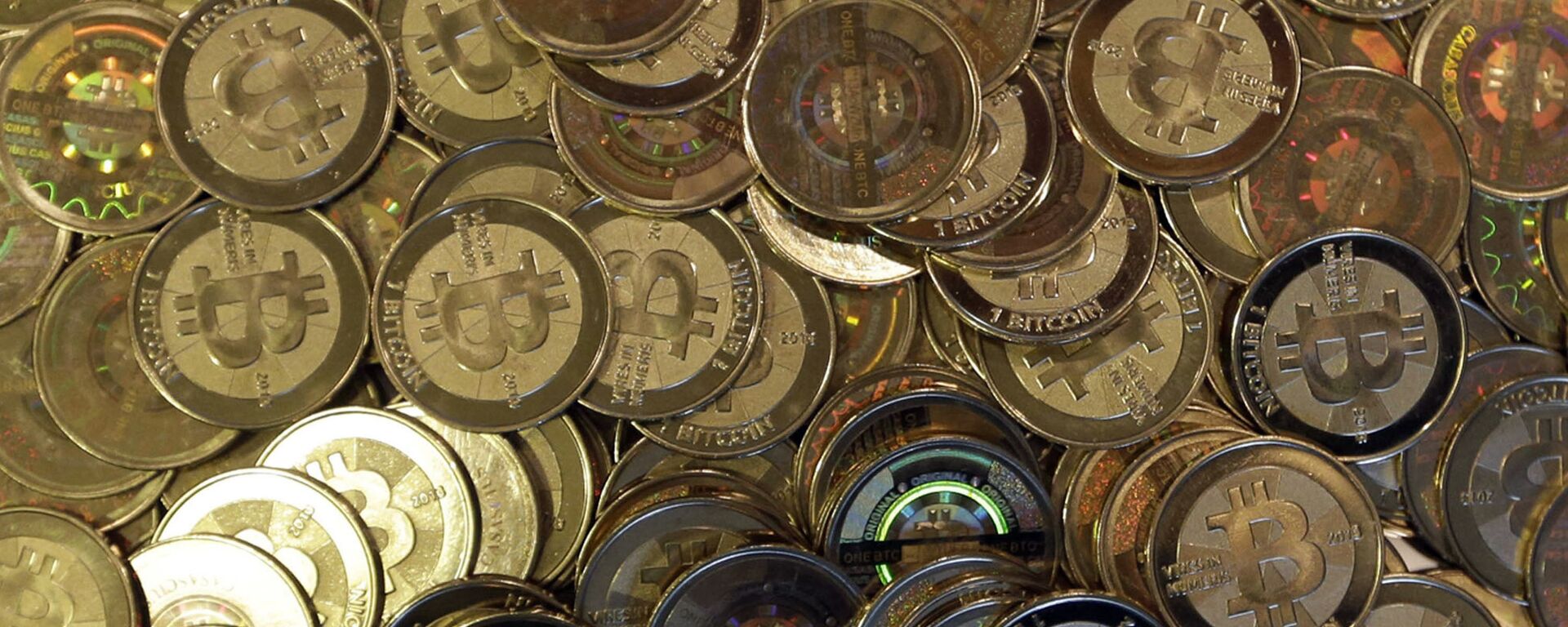 This April 3, 2013, file photo shows bitcoin tokens in Sandy, Utah. Unidentified hackers broke into the Twitter accounts of technology moguls, politicians, celebrities and major companies Wednesday, July 15, 2020, in an apparent Bitcoin scam - Sputnik International, 1920, 24.09.2021