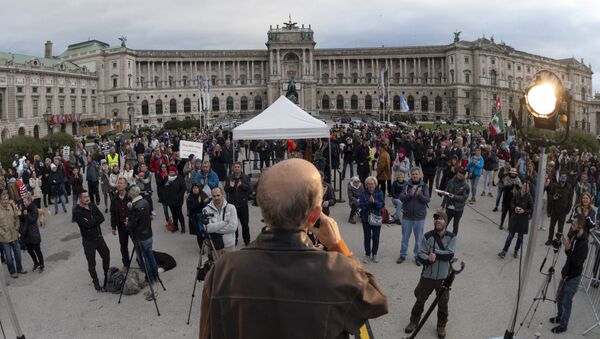 People attend a protest against Austrian government's restrictions implied due to the new corona virus Covid-19, outside of the Hofburg palace in Vienna, Austria on October 31, 2020.  - Sputnik International