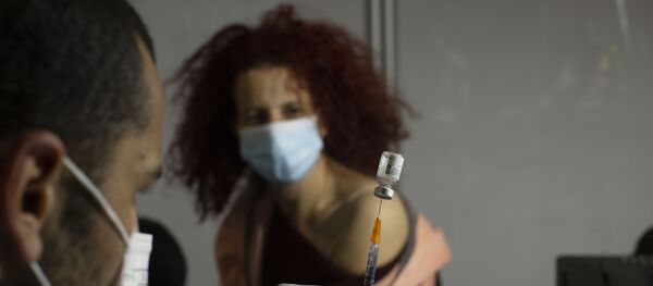 A medical professional prepares to administer the Pfizer COVID-19 vaccine to a woman at a makeshift vaccination center in a sports arena in Jerusalem, Thursday, Jan. 14, 2021. A medical professional prepares to administer the Pfizer COVID-19 vaccine to a woman at a makeshift vaccination center in a sports arena in Jerusalem, Thursday, Jan. 14, 2021. - Sputnik International