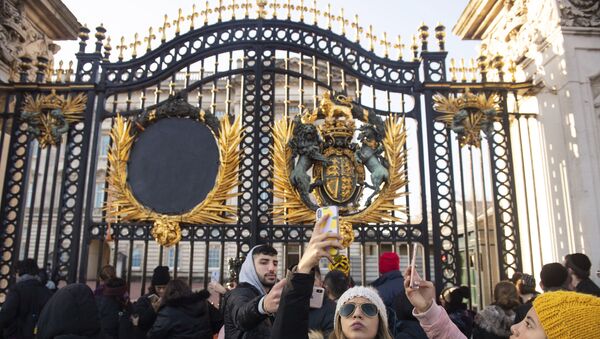 Tourists take photos outside the gates of Buckingham Palace, following a statement by Britain's Queen Elizabeth II and Buckingham Palace, in London, Sunday Jan. 19, 2020 - Sputnik International