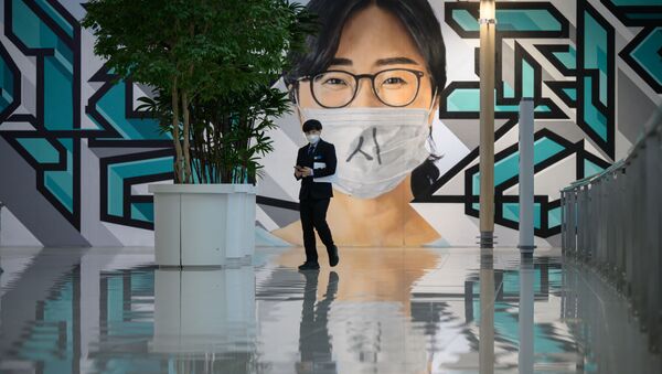 A staff member walks before a mural at Incheon international airport on December 29, 2020, amid the Covid-19 coronavirus pandemic - Sputnik International