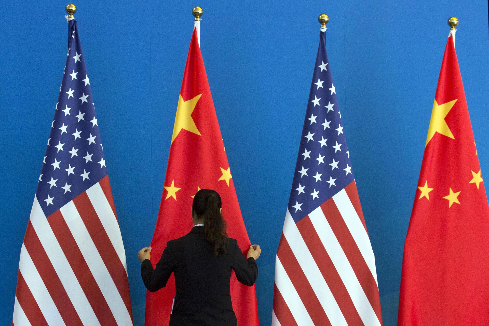 A Chinese woman adjusts the Chinese national flag near U.S. national flags before a Strategic Dialogue expanded meeting that's part of the U.S.-China Strategic and Economic Dialogue at the Diaoyutai State Guesthouse in Beijing, Thursday, July 10, 2014 - Sputnik International, 1920, 14.11.2022