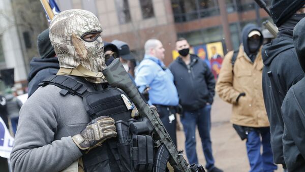 An armed protestor stands outside the Ohio Statehouse Sunday, Jan. 17, 2021, in Columbus, Ohio - Sputnik International