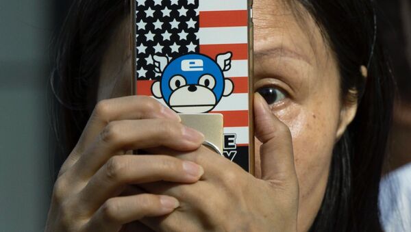 A woman takes a photo with a phone that has a United States flag themed cover outside the United States Consulate in Chengdu in southwest China's Sichuan province on Sunday, July 26, 2020 - Sputnik International