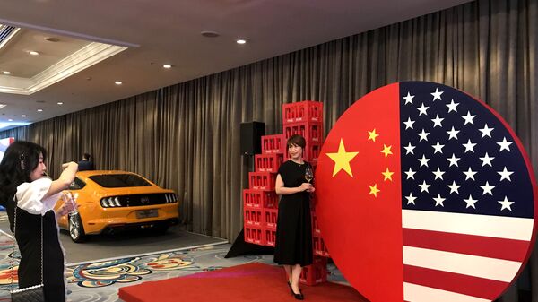 Two women take a photo at a display representing the US and Chinese flags at a reception marking 40 years of diplomatic relations between the US and China, at a hotel in Beijing on June 21, 2019 - Sputnik International