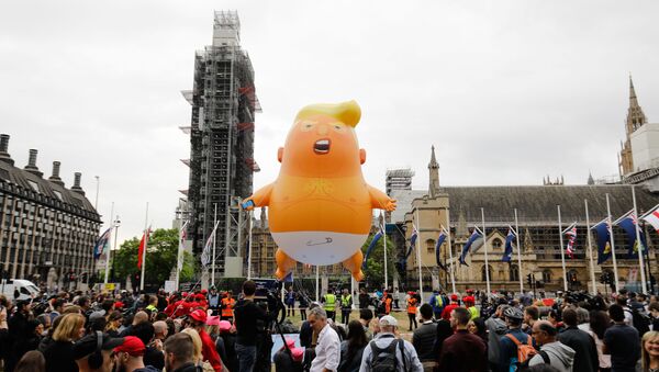 A giant balloon depicting US President Donald Trump as an orange baby floats above anti-Trump demonstrators in Parliament Square outside the Houses of Parliament in London on June 4, 2019, on the second day of Trump's three-day State Visit to the UK. - Sputnik International