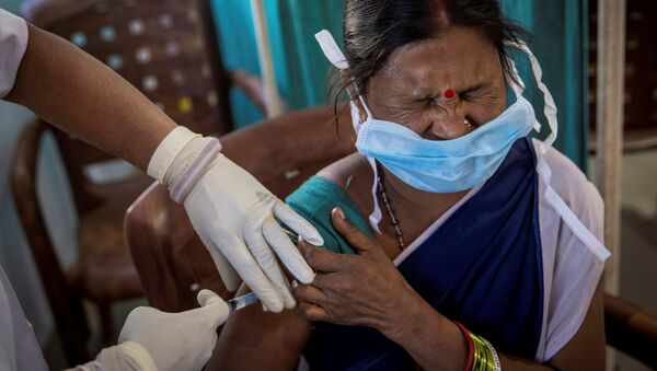 A healthcare worker winces as she receives a dose of COVISHIELD, a COVID-19 vaccine manufactured by Serum Institute of India, during one of the world's largest COVID-19 vaccination campaigns at Mathalput Community Health Centre in Koraput district of the eastern state of Odisha, India, 16 January 2021. - Sputnik International