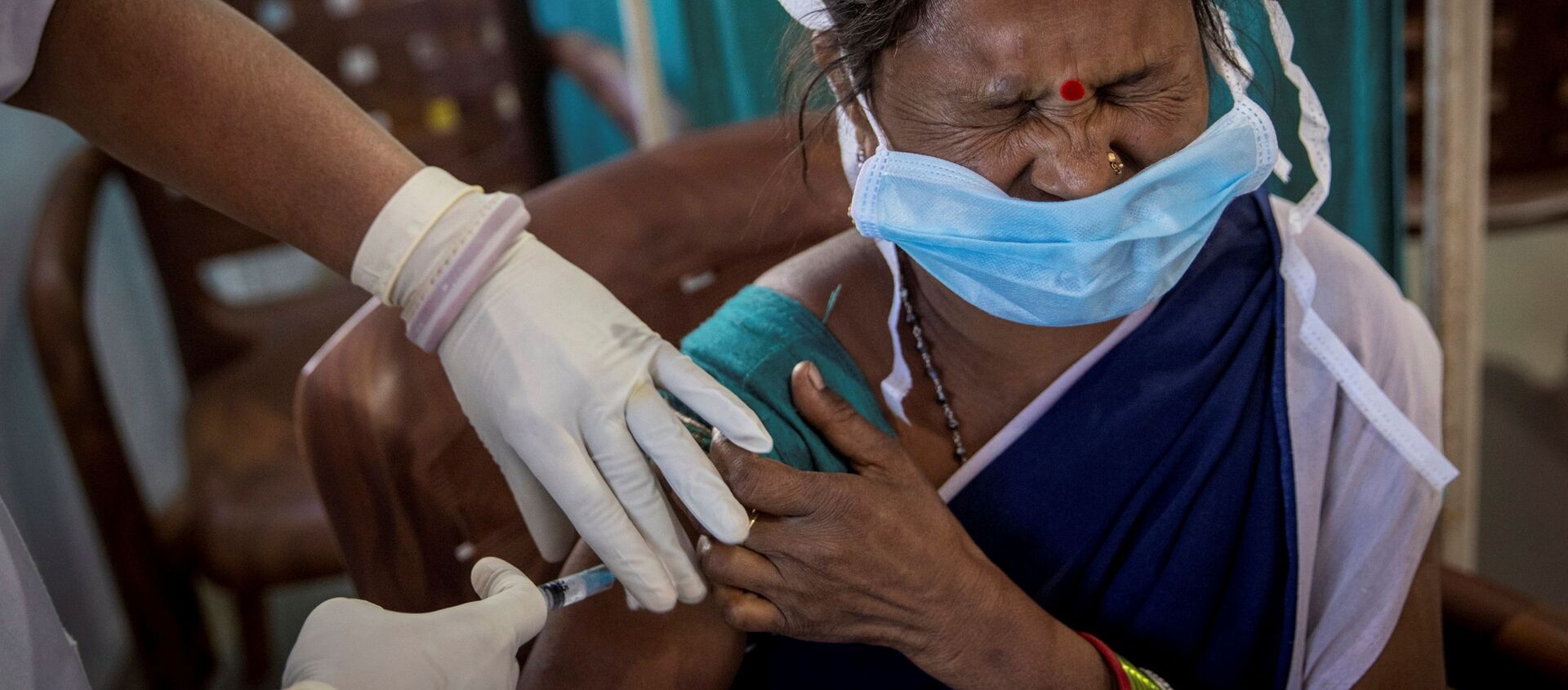 A healthcare worker winces as she receives a dose of COVISHIELD, a COVID-19 vaccine manufactured by Serum Institute of India, during one of the world's largest COVID-19 vaccination campaigns at Mathalput Community Health Centre in Koraput district of the eastern state of Odisha, India, 16 January 2021. - Sputnik International, 1920, 20.01.2021