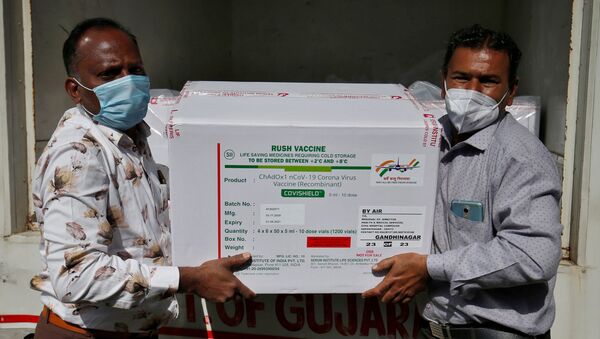 Officials unload boxes containing vials of COVISHIELD, a coronavirus disease (COVID-19) vaccine manufactured by Serum Institute of India, after a consignment of the vaccines arrived from the western city of Pune for its distribution, outside a vaccination storage centre in Ahmedabad, India, January 12, 2021. - Sputnik International