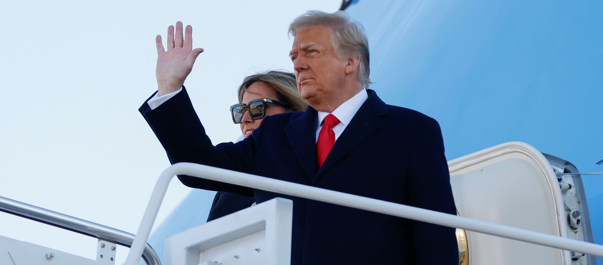 U.S. President Donald Trump, accompanied by first lady Melania Trump, waves as he boards Air Force One at Joint Base Andrews, Maryland, U.S., January 20, 2021. REUTERS/Carlos Barria - Sputnik International, 1920, 20.01.2021