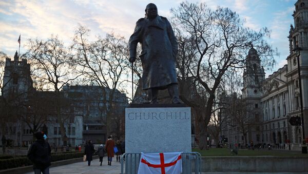 A person wearing a face mask looks at the Winston Churchill statue in Parliament square, in London - Sputnik International